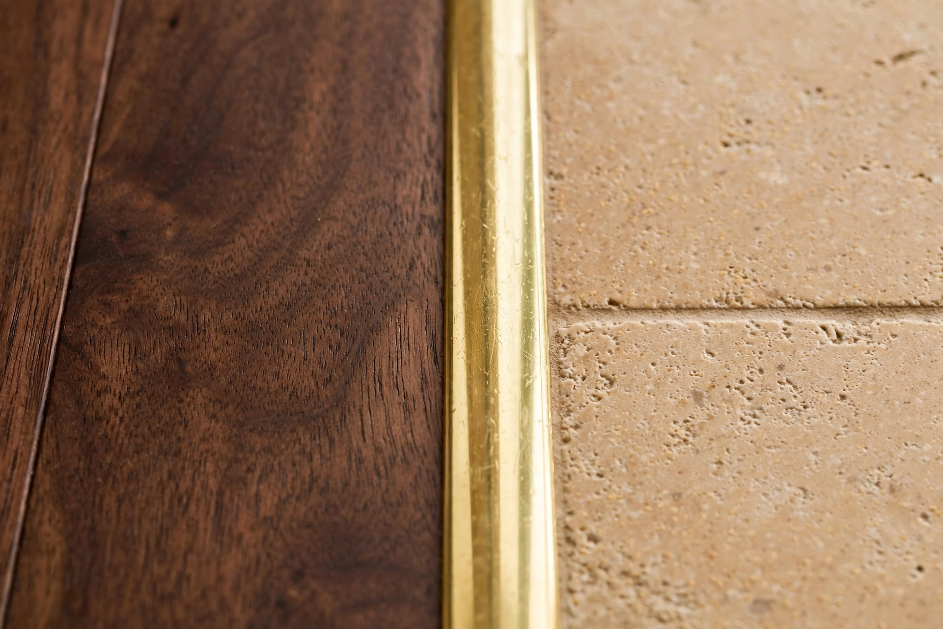 Brass threshold between wood and tile floors